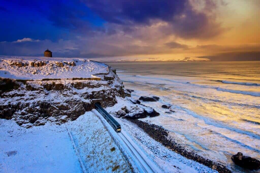 Train comng through the tunnell at Downhill and mussenden temple on the cliff above