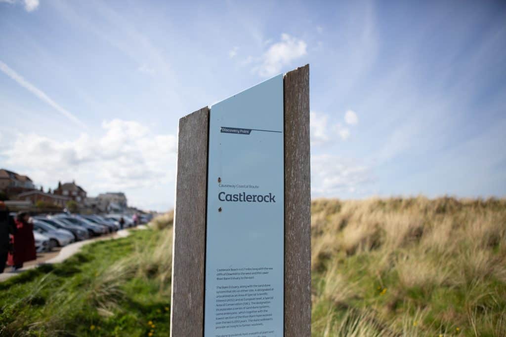 a sign on the side of a road near a field in castlerock northern ireland